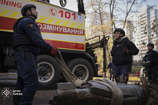 emergency services personnel remove part of a Russian missile that hit an apartment house during massive missile attack in Kyiv, Ukraine, Sunday, Nov. 17, 2024. 