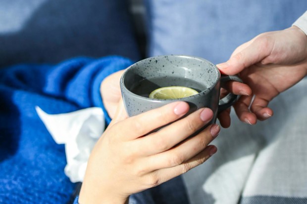 Person holding grey ceramic mug
