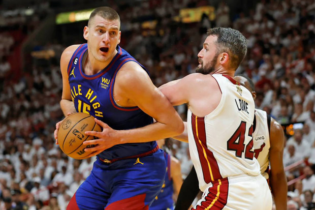 The Denver Nuggets' Nikola Jokic (15) drives against the Miami Heat's Kevin Love (42) during the first half of Game 3 of the NBA Finals at the Kaseya Center on Wednesday, June 7, 2023, in Miami. (Al Diaz/Miami Herald/Tribune News Service via Getty Images)