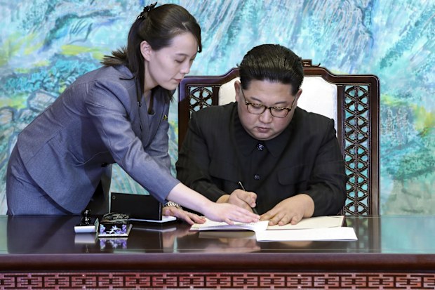 North Korean leader Kim Jong Un signs a joint declaration, with the help of his sister Kim Yo Jong (L), a senior official of the ruling Workers' Party, after talks with South Korean President Moon Jae In at the House of Peace in the border village of Panmunjeom on April 27, 2018. 