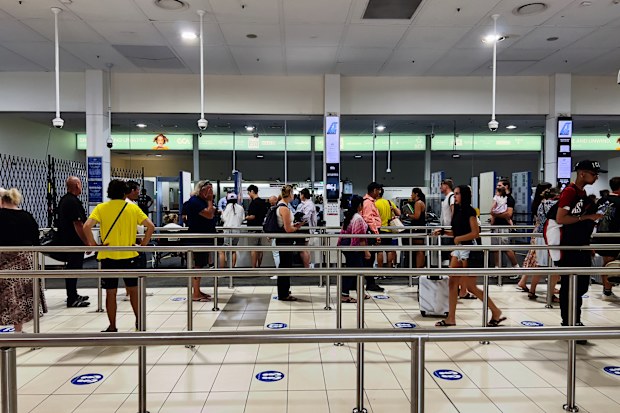 Horizontal photo of people moving along the designated lanes towards the baggage inspection counters and the Departure Lounge at Coolangatta Airport, Gold Coast Queensland.