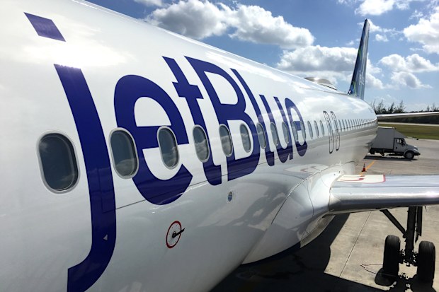 George Town, Cayman Islands - December 21, 2017: Land operations and boarding in Owen Roberts Intl. Airport in Grand Cayman Islands. Close up of a JetBlue plane in a sunny day.