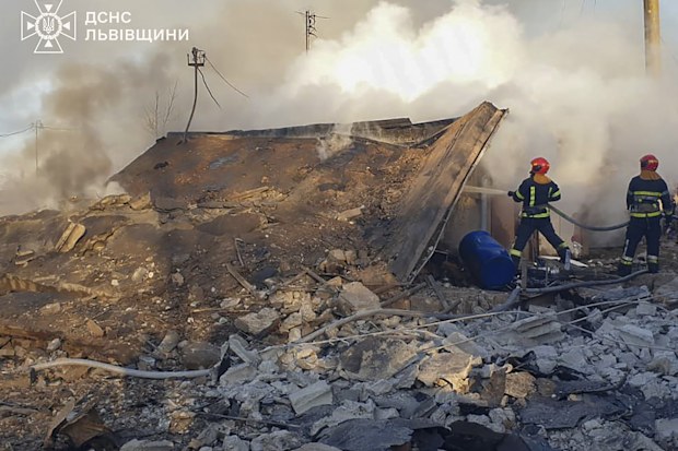 emergency services personnel work to extinguish a fire following a Russian rocket attack in Lviv, Ukraine, Sunday, Nov. 17, 2024. 
