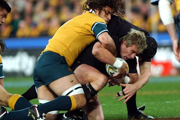Justin Marshall goes to ground under the weight of George Smith's tackle.