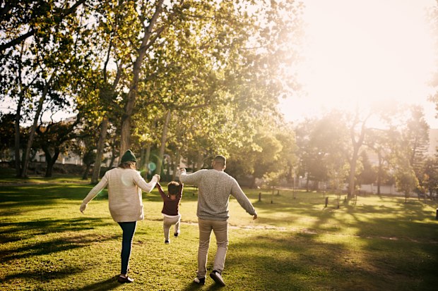 Rearview shot of a couple having fun with their little son at the park