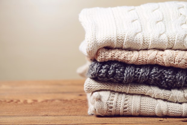 stack of sweaters on a wooden table