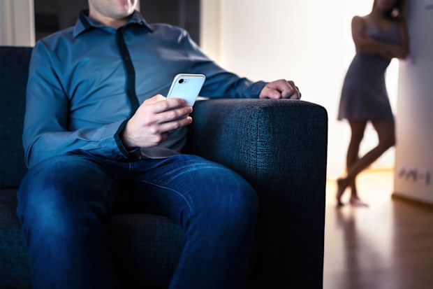 Jealous woman and cheating man with a phone. Infidelity, jealousy and betrayal. Cheater husband texting with mistress and secret lover. Suspicious wife peeking and spying. Unfaithful sneaky boyfriend.