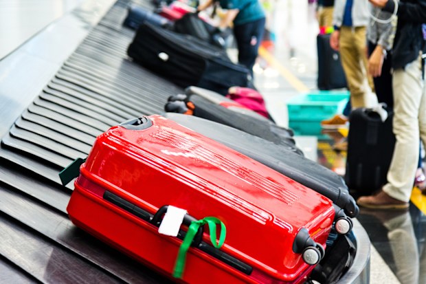 Luggages moving on airport conveyor belt. suitcase with ribbon