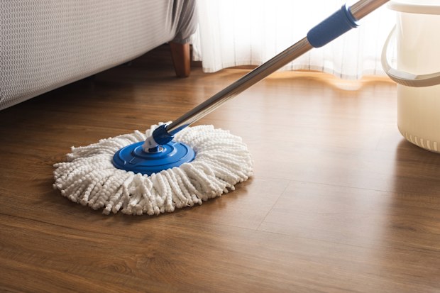 Mop cleaning on wooden floor in house