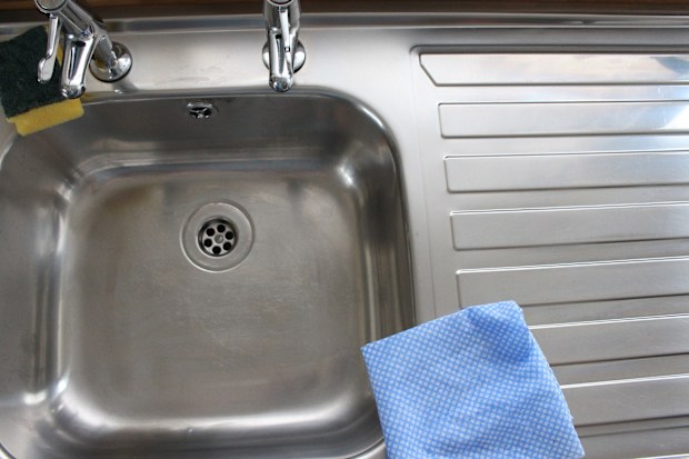 A photograph of home interior, domestic kitchen sink with cleaning material