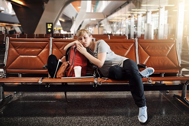 Full length shot of an attractive young woman sleeping in an airport