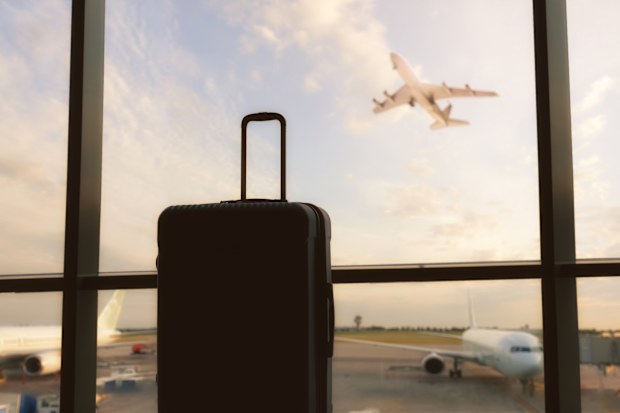 Go on an adventure! Suitcase near window at the airport. Concept of lost baggage.