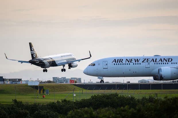 Auckland, New Zealand  January 31 2025: Air New Zealand ZK-OXA Airbus A320-232 landing at Auckland International Airport. Another Air NZ flight waiting on the runway.