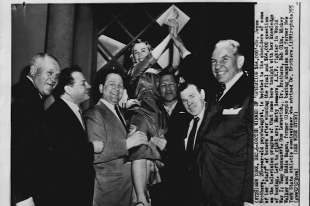 Doctor Winner of 'Operation $64,000' - Dr Joyce Brothers, 28-year-old psychologist, is hoisted to the shoulders of some of her "staff" of boxers after winning the final and $64,000 question on the the television program of that name.