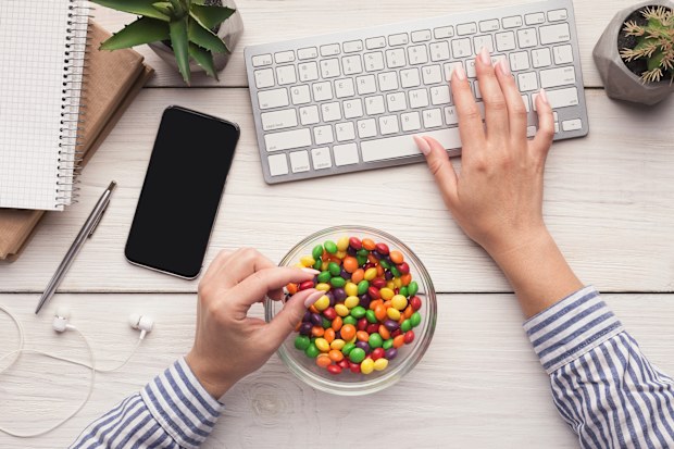  Work space with laptop, candies and woman hands on white background