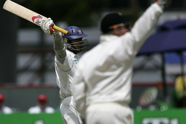 Kumar Sangakkara of Sri Lanka celebrates scoring 100 runs as Brendon McCullum of New Zealand celebates running out Muttiah Muralitharan during a 2006 Test.