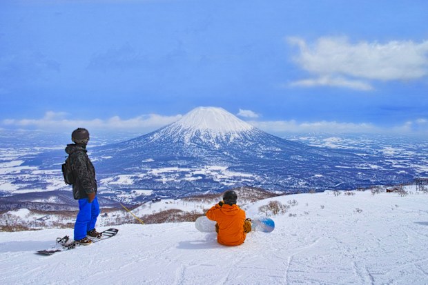 Niseko, Hokkaido, Japan --March 23, 2022: Spring skiing Niseko ski resort, snowboarders before skiing overlooking Mt. Yotei