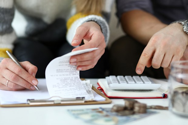 Close-up view of man and woman making account of family income. 