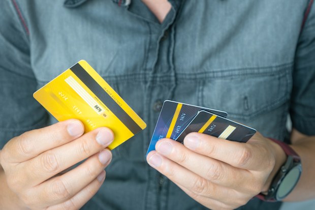 Man holding several credit cards and he is choosing a credit card to pay and spend Payment for goods via credit card. Finance and banking concept.