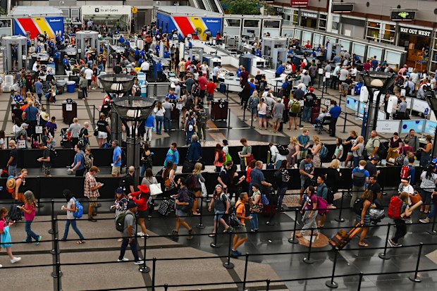 Crowds of travelers in long queue at TSA Security Check at Denver International Airport 