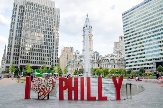 I love Philly sign at Love Park in Philadelphia during summer day. Fountain and City Hall in background.
