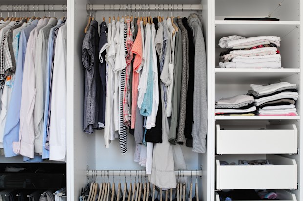 Open wardrobe inside. Men and women clothes.
