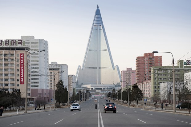Pyongyang, North Korea, December 16, 2011: City center with skyscraper and traffic. The Ryugyong hotel was many years unfinished. A foreign company covered the facade with glass and now it looks not like a ruin any more. Inside it is still empty.