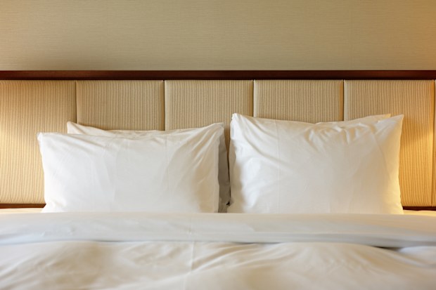 A king-size luxury hotel bed with four pillows.
