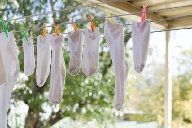Mismatching white socks hanging to dry on a washing line on a beautiful sunny day