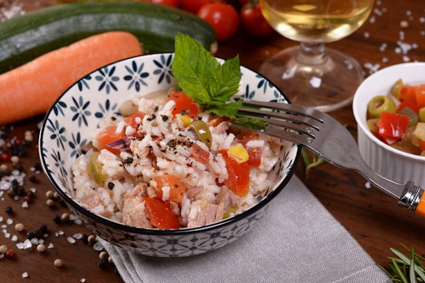 Bowl with rice salad and seasoning on the table