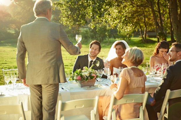Rear view shot of a father making a toast at a wedding reception