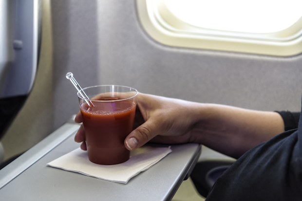 glas of tomato juice on a table in an airplane close to the airplane window