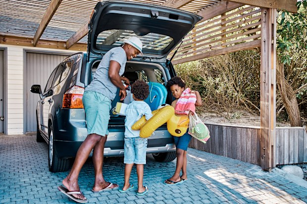 A family packing the car to leave for summer vacation. 