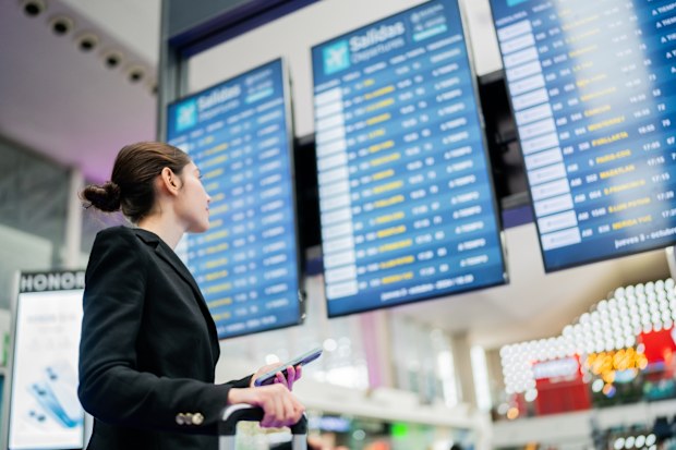 Young businesswoman looking control panel at airport