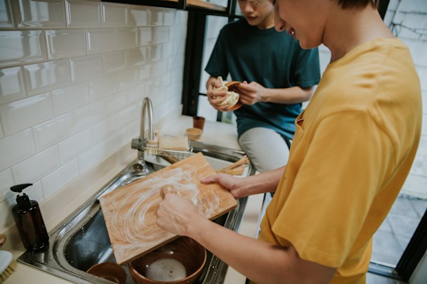 person Washing Up At Home Using Eco Dish Brush For Sustainable Lifestyle