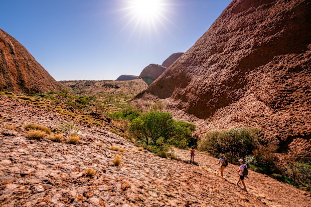 People walking under blazing sun on hot summer sunny day in the Olgas NT central outback Australia