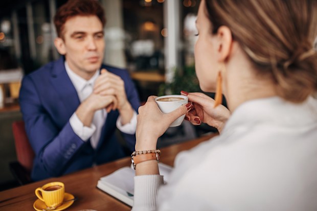 Handsome young businessman sitting on coffee with a beautiful woman in cafe.