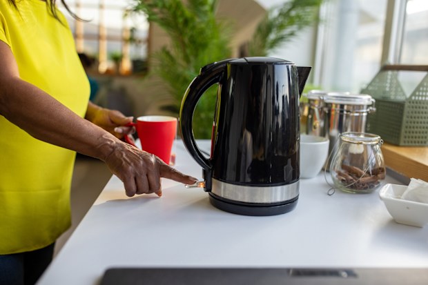 Woman turning on kettle