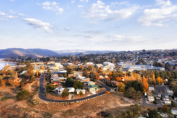 Streets of Jindabyne town on Jindabyne lake of Snowy river and hydro dam in AUstralian Snowy Mountains - aerial view.