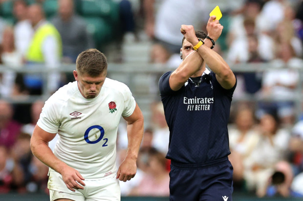 Owen Farrell receives a yellow card from referee Nika Amashukeli after a high tackle on Taine Basham of Wales.