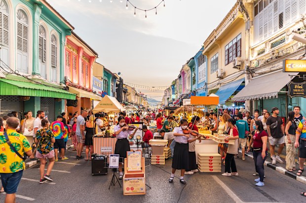 PHUKET, THAILAND - April 24, 2023: Tourists are walking on the Phuket Walking Street is a night market that takes over the beautiful Thalang Road in Phuket Old Town every Sunday evening