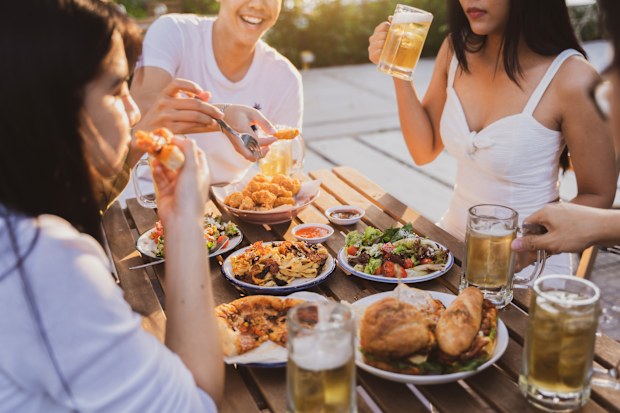 Group holiday party of asian people Eating dinner and drinking beer at home