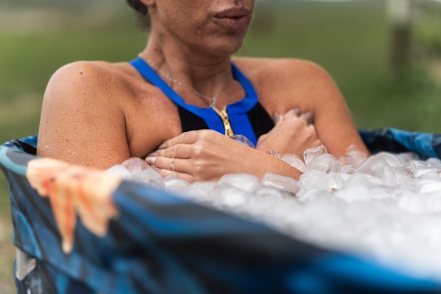 Female athlete is taking an ice bath for recovery after a hard training session