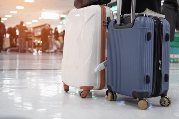 Tourist Travel with black large suitcases or baggage in lobby hotel waiting room or check in line at airport. Trip vacation or holiday tourism insurance concept