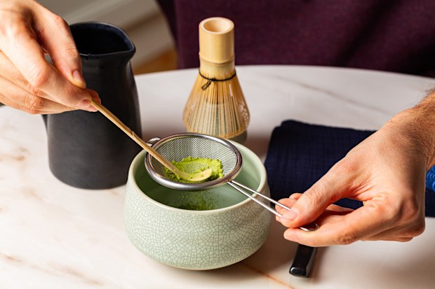 Man hands, Cooking green matcha tea during the Japanese ceremony. Traditiobal kit, Bamboo whisk and beverage, spoon shashaku, heated tea bowl known as a chawan. Horizontal image. .
