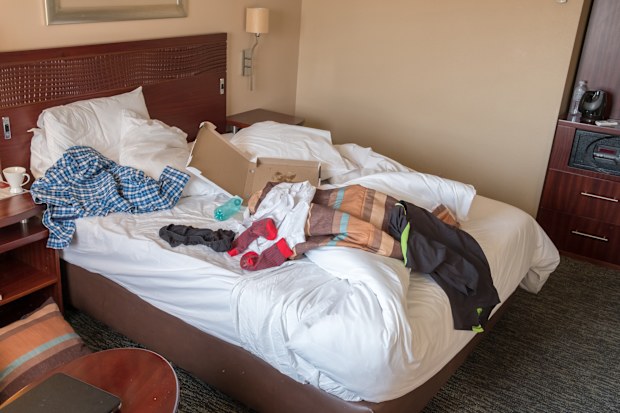 messy hotel room bed after a night of partying