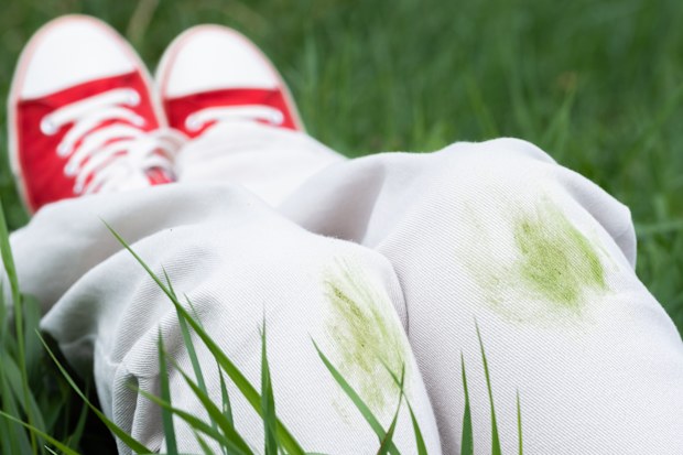 Close up of dirty grass stains on white jeans during summer activity. 