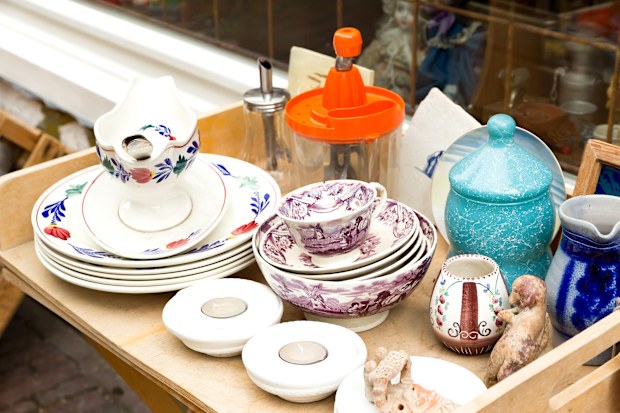 Kitchenware stacked on a shelf at a second-hand store