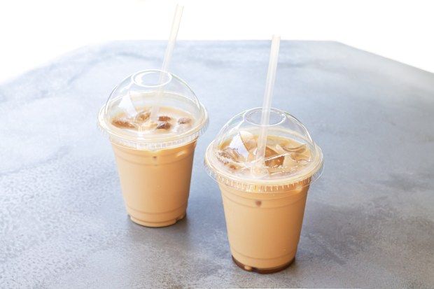 Two iced coffee or latte in take away plastic cup on street cafe stone table