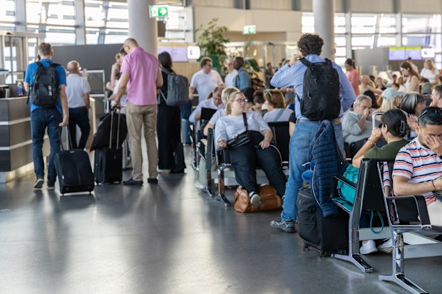 Vienna, Austria - 09 September 2025: Crowd in the airport terminal moves through check-in counters and security lines, travelers carrying luggage and boarding passes, reflecting organized airport transit